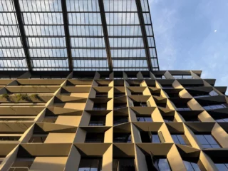 Image 12: Post #6 in our series featuring outstanding pictures of #punggoldigitaldistrict taken by talented WOHAcians for our company-wide photo competition. This facade detail in was captured by @kishinatsuki. Punggol Digital District (PDD) is a 50-hectare integrated district in Singapore designed to bring jobs, education, and social amenities closer to homes. It creates a highly liveable, vibrant, sustainable,and biophilic environment through innovative urban planning, balancing density with ample greenery, and fostering deep integration across its multiple strata. The direct synergy between the physically connected industry and academia creates an ecosystem for collaboration and one that spurs innovation. PDD’s strategic planning enables a significant portion of the site’s vegetation to be conserved and transformed into a Community Park, thereby preserving a precious and generous green breathing space at the heart of the district. Design Inception: 2017 Client: @jtc_sg #punggoldigitaldistrict #masterplan #futurecity #urbanplanning #greencity #singapore #singaporearchitecture #businesspark #mixeduse #regenerative #design #education #educationalarchitecture #campus #boulevard #carlite #pedestrianfriendly #pedestrianbridge #bridge #jtcsg #singaporetech #singaporeinstituteoftechnology #woha